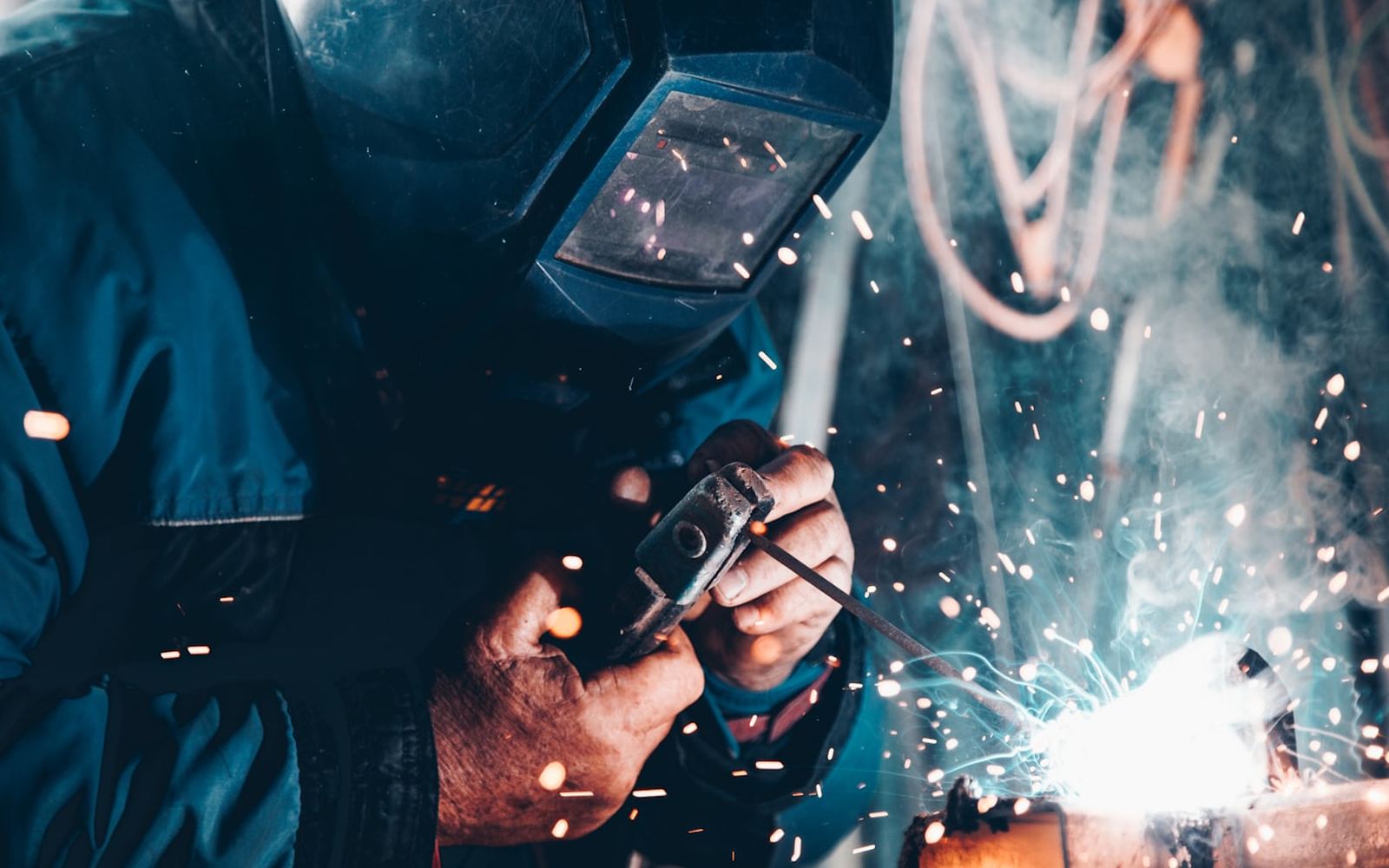 A welder at work, sparks flying from the joint