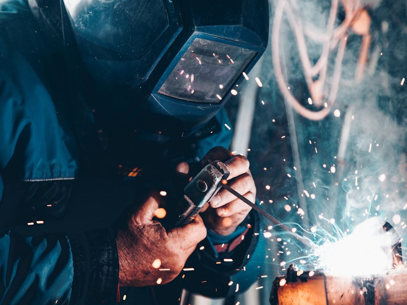 A welder at work, sparks flying from the joint