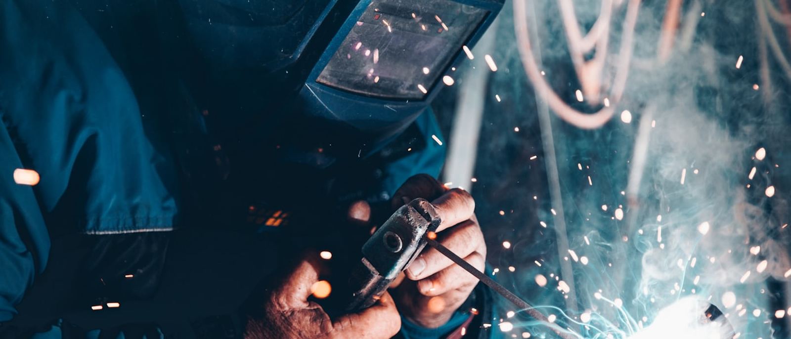 A welder at work, sparks flying from the joint